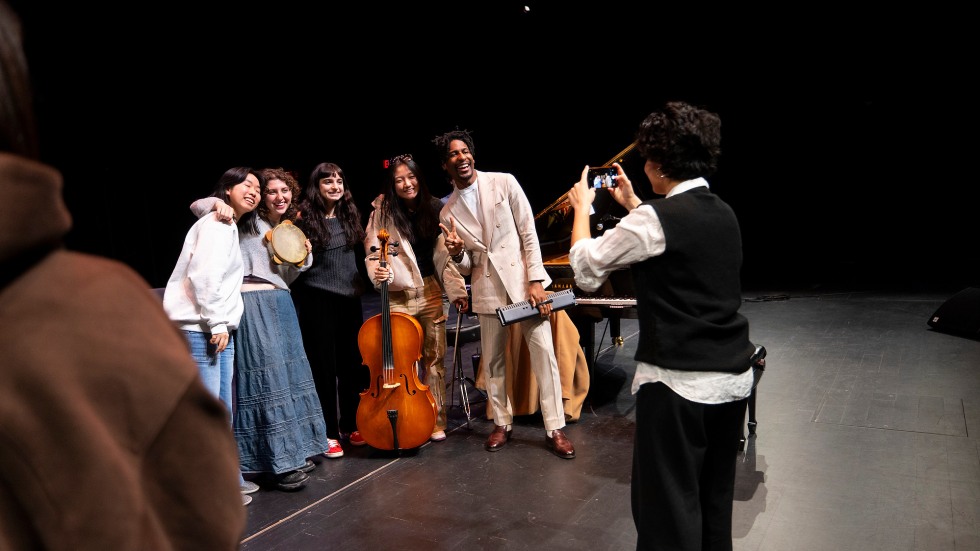 students posing for a photo with Jon Batiste